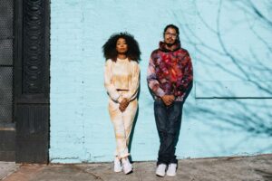 Lifestyle portrait of a fashionable, young millennials in Brooklyn, Park Slope district of NYC. They’re wearing trendy tie dye clothing, posing with an attitude.