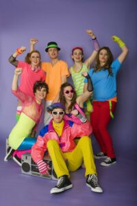 A group of retro styled teen dancers with a boom box