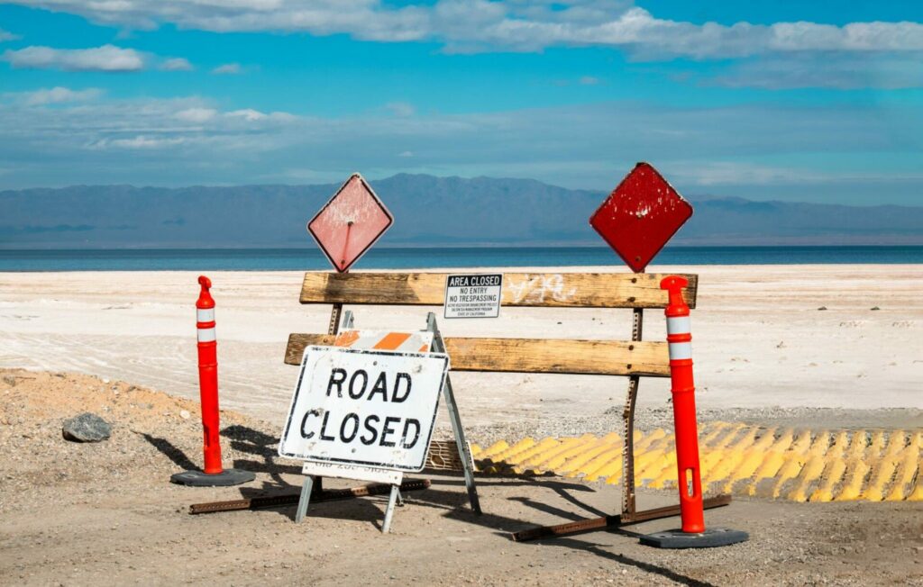 A road blockade and closed sign with warnings not to enter at the Salton Sea